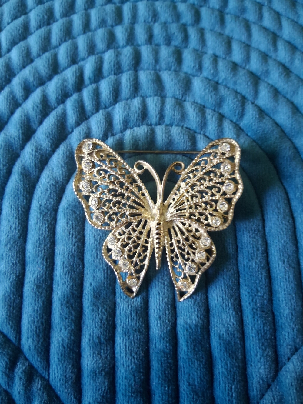 Vintage silver-tone filigree butterfly brooch adorned with rhinestones